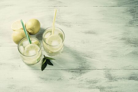 Homemade lemonade with mint from lemone and orange, citrus refreshig beverage in glass. Vintage stylization, retro film filterの写真素材