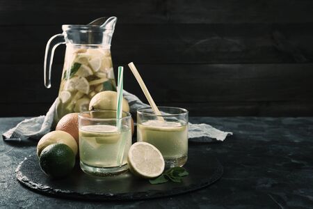 Homemade lemonade with mint from lemone and orange, citrus refreshig beverage in glass. Vintage stylization, retro film filterの写真素材