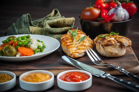 Fried chicken fillet and boiled vegetables, barbecue meat. Delicious dinner, food background, selective focusの写真素材