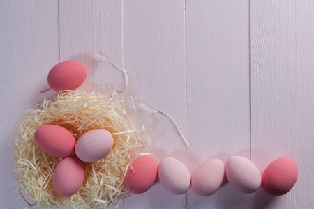 Happy easter painted eggs on wooden colorful table, holiday background for your decoration. Copy spaceの写真素材