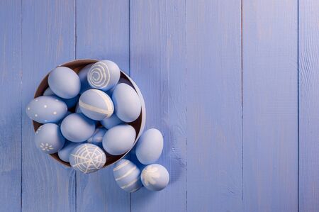 Happy easter painted eggs on wooden colorful table, holiday background for your decoration. Copy spaceの写真素材