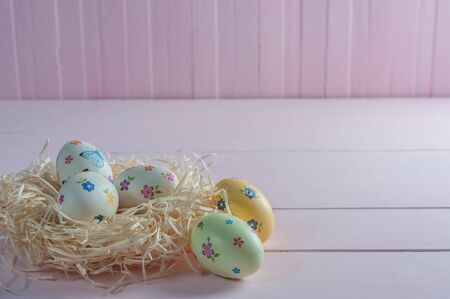 Happy easter painted eggs on wooden colorful table, holiday background for your decoration. Copy spaceの写真素材