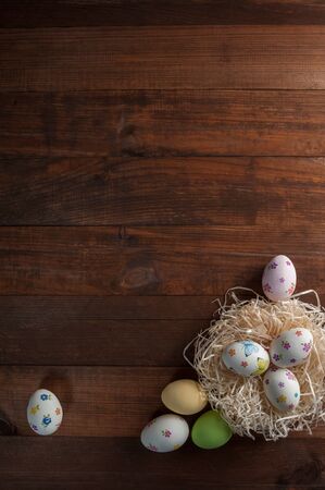 Happy easter painted eggs on wooden colorful table, holiday background for your decoration. Copy spaceの写真素材