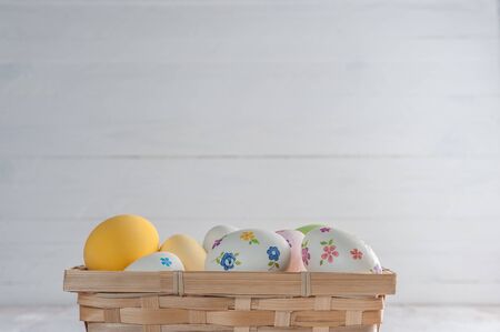 Happy easter painted eggs on wooden colorful table, holiday background for your decoration. Copy spaceの写真素材