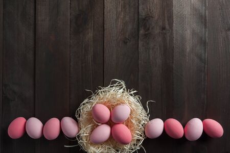 Happy easter painted eggs on wooden colorful table, holiday background for your decoration. Copy spaceの写真素材