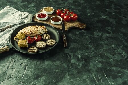 Fried chicken fillet and grilled vegetables, delicious barbecue dinner, food background. Vintage stylization, retro film filterの写真素材