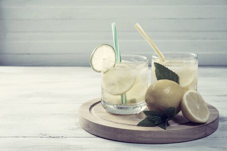 Homemade lemonade with mint from lemone and orange, citrus refreshig beverage in glass. Vintage stylization, retro film filterの写真素材