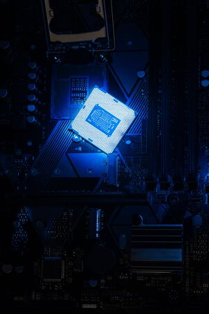 Multi core CPU installation on computer motherbord. PC assembly or upgrade on modern chipset. Electronic concept with processor, low lightsの写真素材