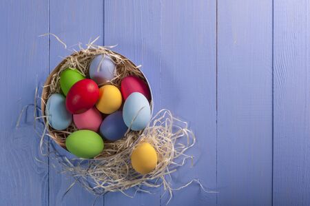 Easter painted eggs on wooden colorful table, holiday background for your decoration. Egg hunt, copy spaceの写真素材