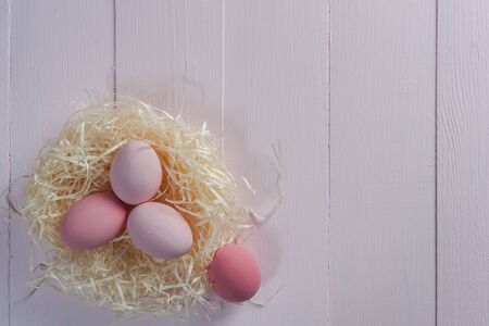 Easter painted eggs on wooden colorful table, holiday background for your decoration. Egg hunt, copy spaceの写真素材
