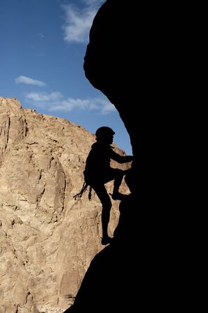 Rock climber silhouette, climbs up the mountain. Extreme sportの写真素材