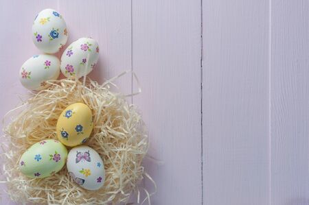 Happy easter painted eggs on wooden colorful table, holiday background for your decoration. Egg hunt, copy spaceの写真素材