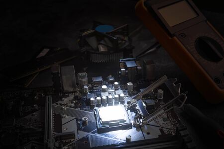 Multi core CPU installation on computer motherbord. PC assembly or upgrade on modern chipset. Electronic concept with processor, low lightsの写真素材