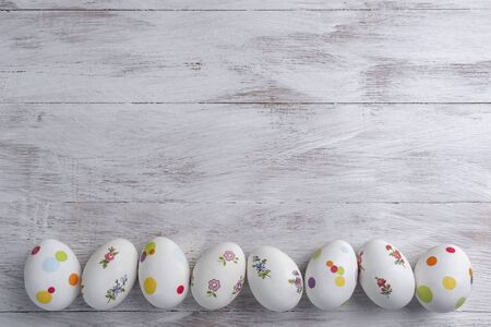 Happy easter painted eggs on wooden colorful table, holiday background for your decoration. Egg hunt, copy spaceの写真素材