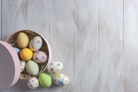 Happy easter painted eggs on wooden colorful table, holiday background for your decoration. Egg hunt, copy spaceの写真素材