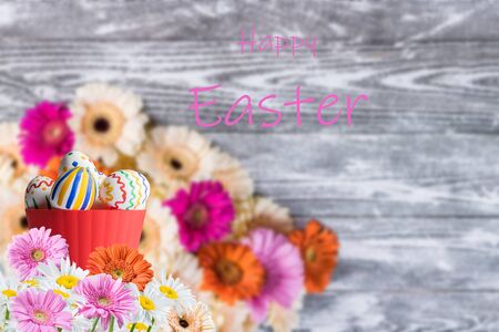 Easter painted eggs on and flowers, holiday background for your decoration. Egg hunt, copy space, "Happy Easter" letteringの写真素材