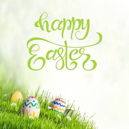 Easter colorful eggs and flowers, holiday background for your decoration. Egg hunt, copy space, "Happy Easter" hand draw letteringの写真素材