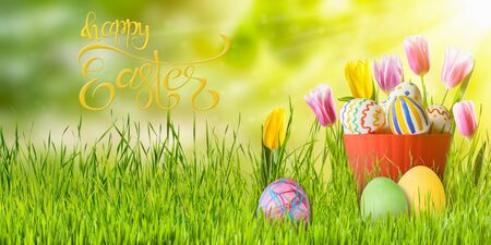Easter colorful eggs and flowers, holiday background for your decoration. Egg hunt, copy space, "Happy Easter" hand draw letteringの写真素材