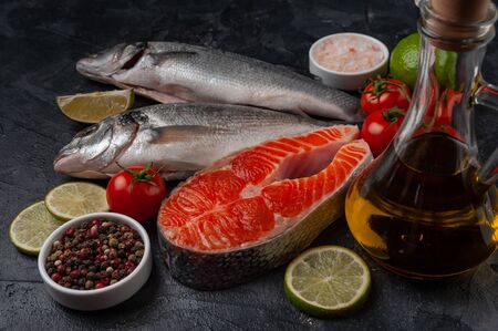 Fresh salmon and seabass fishes on bord prepared to cooking, vegetables and fresh sea food. Cooking background, selective focusの写真素材