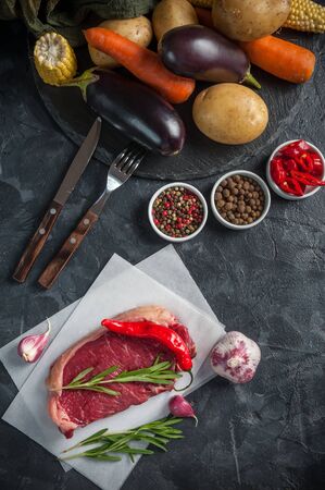 Beef steaks rib eye ready to cooking, culinary background. Fresh raw meat on wooden cutting board with rosemary, flat layの写真素材