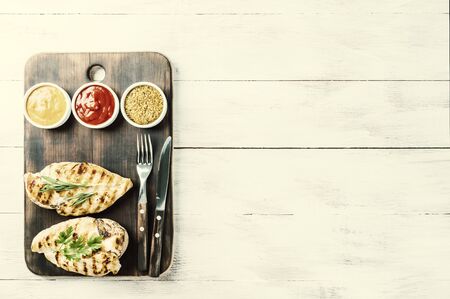 Delicious barbecue dinner from fried chicken fillet and sauces, flat lay food background. Retro film filter, vintag stylizationの写真素材