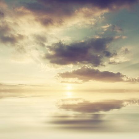 Nature background with sunset or sunrise above sea, beautiful couds in sky, seascape. Vintage stylization, retro film filterの写真素材