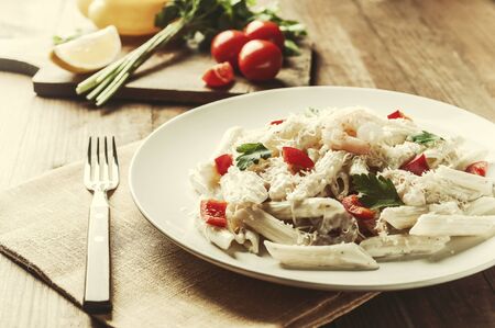 Italian spaghetti pasta with sauce and shrimp, cheese parmesan and basil. Food background, flat lay. Retro film filter, vintage stylizationの写真素材