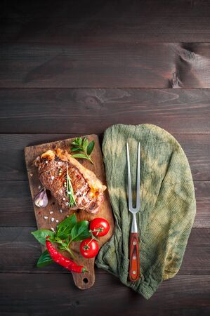 Flat lay beef steaks rib eye fried on grille, culinary background. Grilled meat on wooden cutting board with rosemaryの写真素材