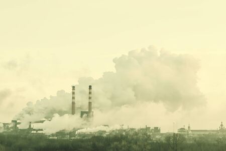 Industrial landscape with pipes and smoke from big plant. Vintage stylization, retro flm filter