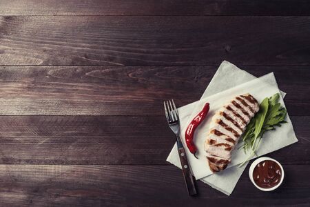 Fried pork fillet and sauce, delicious barbecue dinner, flat lay food background. Vintage stylization, retro film filterの写真素材