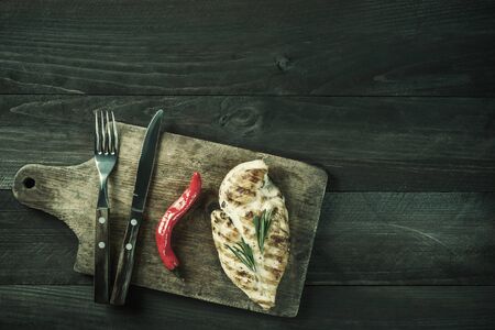 Fried chicken fillet and boiled vegetables, delicious barbecue dinner, flat lay food background. Vintage stylization, retro film filterの写真素材
