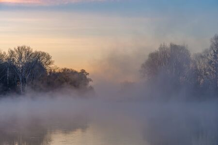Fall landscape with river on sunrise and over water and colorful gentle sky, long exposureの写真素材