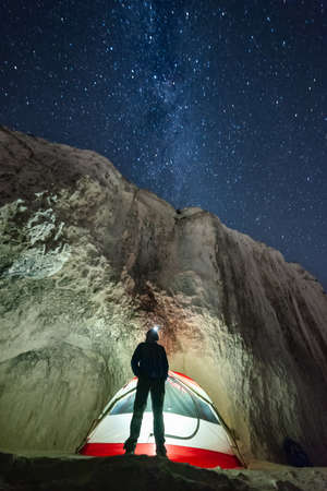 Mountaineer look on night sky with stars, adventure lifestyle, man in mountains.の写真素材
