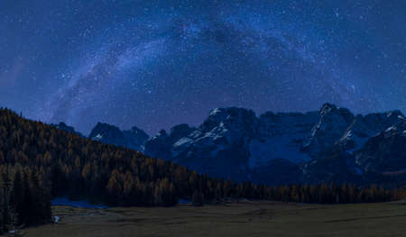 Night autumn landscape with milky way over mountainの写真素材