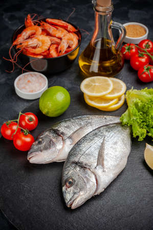 Fresh dorado fishes board prepared to cooking with vegetables and sea food. Cooking background, flat layの写真素材