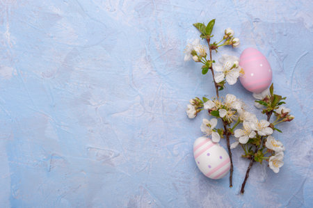 Happy easter card with painted eggs and flowers on colorful table, holiday background for your card. Egg hunt, copy spaceの写真素材