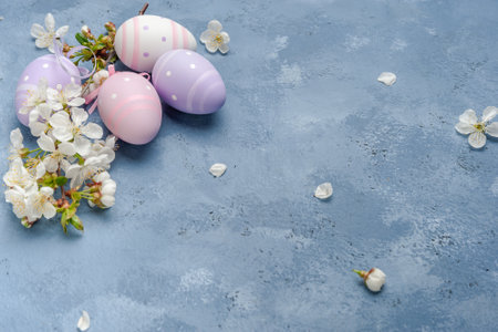 Happy easter card with painted eggs and flowers on colorful table, holiday background for your card. Egg hunt, copy spaceの写真素材