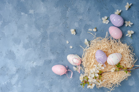 Happy easter card with painted eggs and flowers on colorful table, holiday background for your card. Egg hunt, copy spaceの写真素材