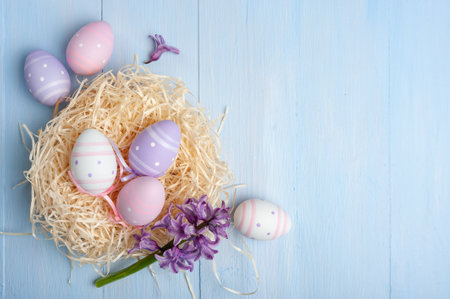 Happy easter card with painted eggs and flowers on colorful table, holiday background for your card. Egg hunt, copy spaceの写真素材