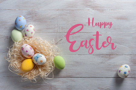 Easter painted egg on wooden rustic table with hand lettering text, holiday background for your decoration. Decoupage eggs on colorful boardsの写真素材