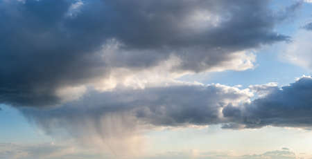 Blue majestic sky with clouds and rainの写真素材