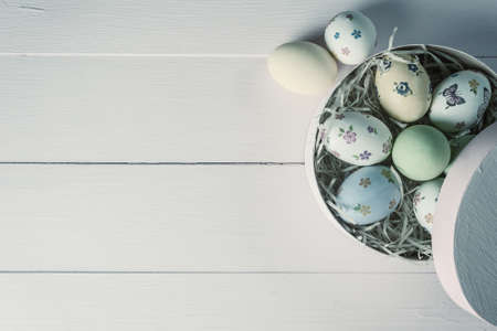 Easter painted eggs on wooden rustic table, holiday background for your decoration. Retro film filter, vintage stylizationの写真素材