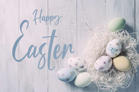 Easter painted eggs on wooden rustic table with hand lettering text, holiday background for your. Retro film filter, vintage stylizationの写真素材