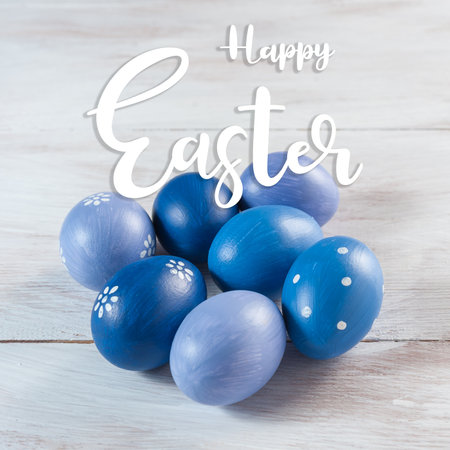 Easter painted eggs and blooming branches on wooden rustic table with hand lettering text, holiday background.の写真素材