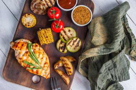 Chicken fried fillet and vegetables for delicious barbecue dinner, flat lay food backgroundの写真素材