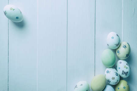 Happy easter painted eggs on wooden table, holiday background for your decoration. Vintage stylization, retro film filterの写真素材