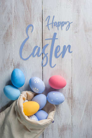 Happy easter painted eggs on wooden table and hand lettering textの写真素材