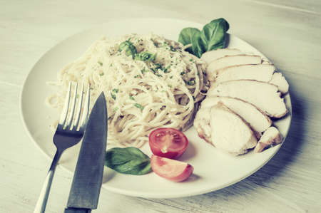 Italian spaghetti pasta with sauce and chicken, cheese parmesan and basil. Food background, flat lay. Retro stylization, vintage film filterの写真素材