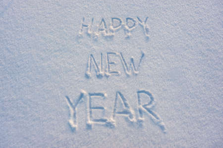 Happy New Year text draw on snow for holiday cardの写真素材