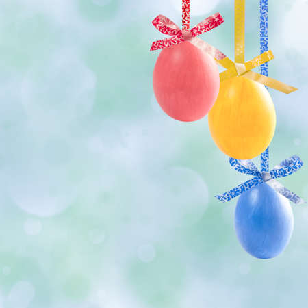Holiday card with colorful easter eggs hang on ribbon and place for your textの写真素材